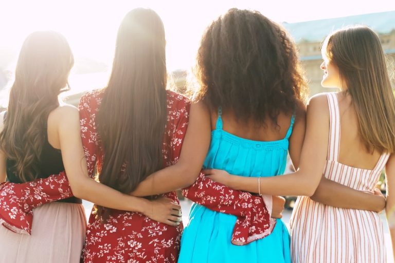 Women standing with arms around each other